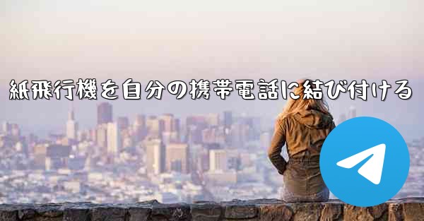 紙飛行機を自分の携帯電話に結び付ける